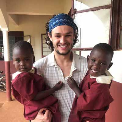 A student holds two children while on a mission trip